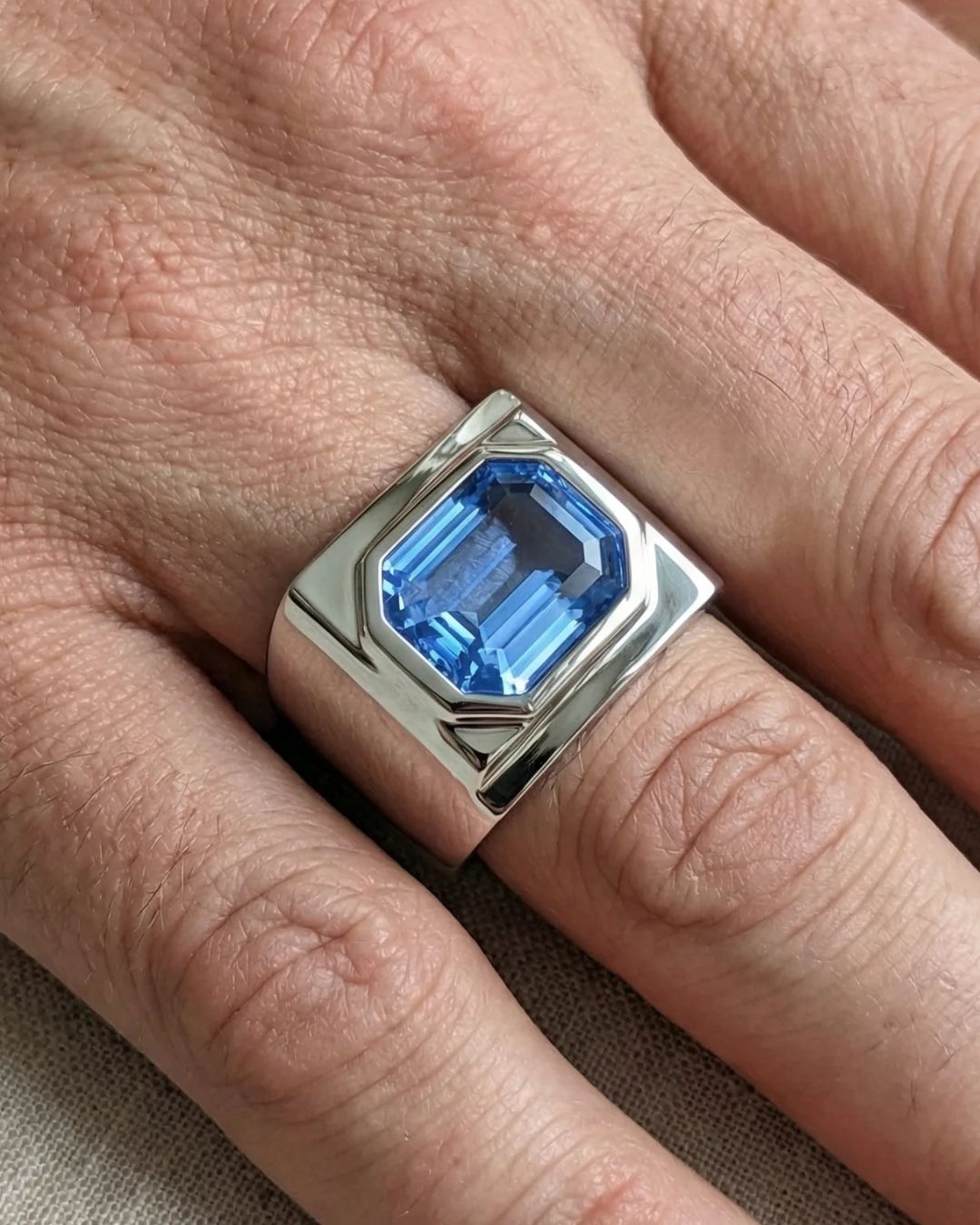 Bague d'homme sertie d'un saphir bleu taille à degrés, portée à la main — Bonnot Paris